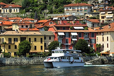 View towards a town with a tourist ferry over Lake Maggiore, Cannero Riviera, Piedmont, Italy, Europe