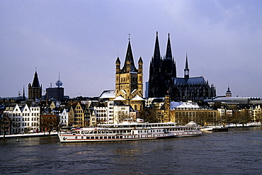 Excursion boat in winter, snow and floods on the Rhine river, in the back the church Gross St. Martin and the Koelner Dom Cologne Cathedral, old town, Cologne, North Rhine-Westphalia, Germany, Europe