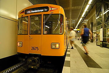 Two passengers running to the new subway line U55, with a traditional yellow subway carrriage, Brandenburger Tor Station, Berlin, Germany, Europe