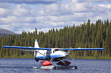 Taxiing de Havilland Canada DHC-3 Otter, Floatplane, Canoe tied to float, bush plane, Caribou Lakes, upper Liard River, Yukon Territory, Canada