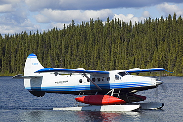 Taxiing de Havilland Canada DHC-3 Otter, Floatplane, Canoe tied to float, bush plane, Caribou Lakes, upper Liard River, Yukon Territory, Canada