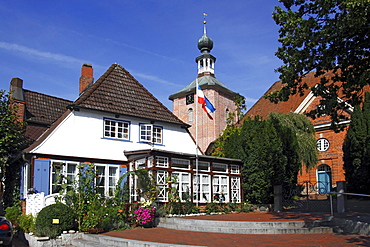 Historic house and protestant church in Schoenberg with Schleswig-Holstein flag, Probstei, Ploen district, Schleswig-Holstein, Germany, Europe