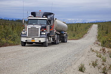 A fuel tank truck on the Denali Highway, a little-used 135-mile long mostly unpaved road which traverses the remote wilderness east of Denali National Park, Alaska, USA