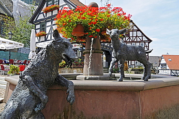 Fountain with sculptures of a wolf and a lamb on the market square with half-timbered houses, Wolfhagen, Habichtswald National Park, Hesse, Germany, Europe