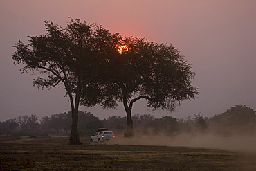 Sunset with all-terrain vehicle in the South Luangwa National Park, Zambia, Africa