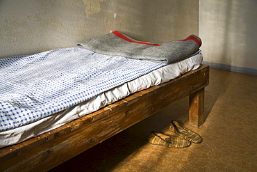 Cot with original bed covers, blanket and slippers, Berlin-Hohenschoenhausen memorial, former prison of the GDR's secret service, Berlin, Germany, Europe