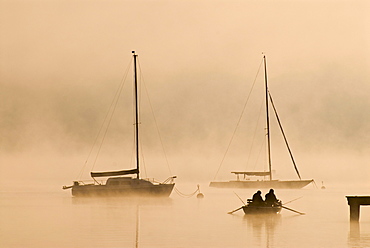 Sailing boats and fog at the southern end of Ammersee lake in Diessen, Bavaria, Germany, Europe