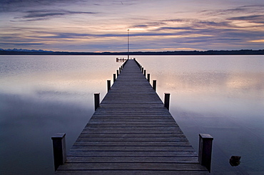 Pier into Lake Starnberg in front of a colorful sunset, near Ambach, Bavaria, Germany, Europe