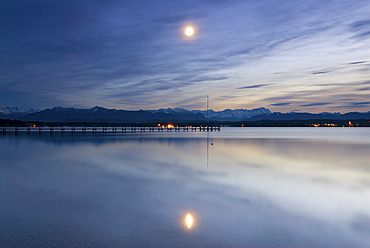 Full moon and its reflection in Lake Starnberg with the Bavarian Alps in the back, near Ambach, Bavaria, Germany, Europe