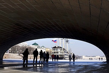 People walking under the Kamennoostrovsky bridge over the Neva River, St. Petersburg, Russia