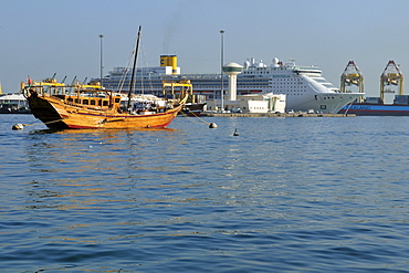 Traditional dhow and modern cruiseship at Mutrah harbor, Muscat, Sultanate of Oman, Arabia, Middle East