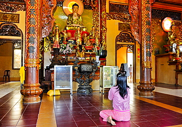 Woman in prayer in a Buddhist temple, Vietnam, Asia