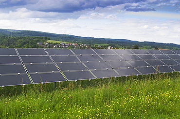 Solar power plant on a green field, photovoltaic system, view of a series of several modules