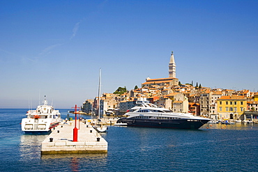 The pier of the southern harbour with motor yacht Sibelle and catamaran against Rovinj historic centre, Istria, Croatia, Europe