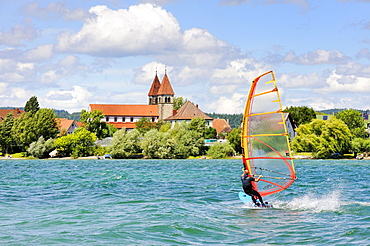 Windsurfer on Lake Constance, shore of Reichenau Island in the back, St. Peter and St. Paul Church, County of Constance, Baden-Wuerttemberg, Germany, Europe