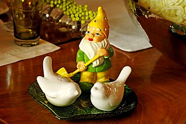 Table decoration, garden gnome behind two porcelain doves, salt and pepper cellar, on a green, shell-shaped plate, Villa Ambiente, Nuremberg, Middle Franconia, Bavaria, Germany, Europe