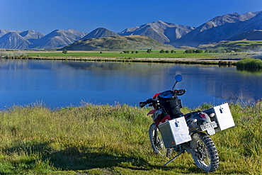 Enduro motorcycle in the morning light on the bank of Maori Lake, South Island, New Zealand