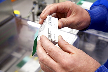 Employee of Boehringer Ingelheim GmbH checking a respiratory drug from a packaging machine in the logistics and packaging center, pharmaceutical company Boehringer Ingelheim GmbH, Ingelheim, Rhineland-Palatinate, Germany, Europe