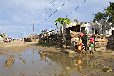 Road with water filled potholes provide breeding grounds for Malaria mosquitoes, Quelimane, Mozambique, Africa