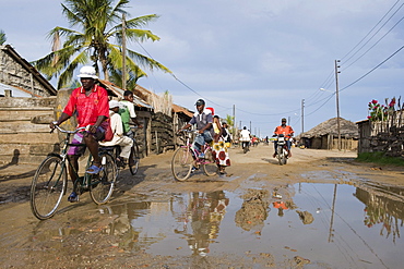 Road with water filled potholes provide breeding grounds for Malaria mosquitoes, Quelimane, Mozambique, Africa