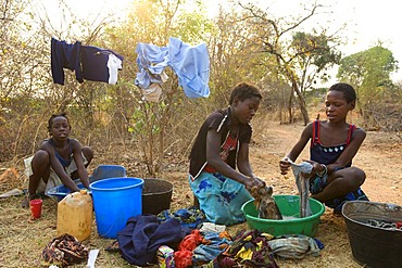 Teenagers washing clothes, washing square, African village Sambona, Southern Province, Republic of Zambia, Africa