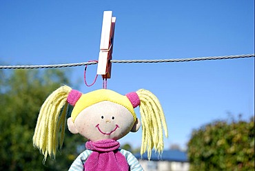 A child's soft toy hanging on washing line to dry after being washed