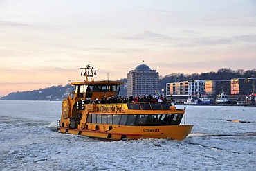 A fully occupied HADAG harbour ferry navigating the ice at the Port of Hamburg, Hamburg, Germany, Europe