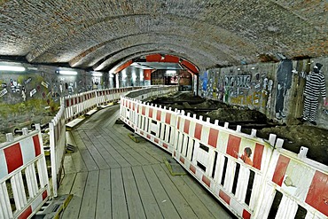 Walkway between building safety barriers through a railway underpass, at night in Hamburg, Germany, Europe