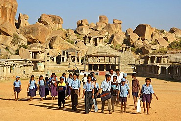 Indian school class in front of temple ruin and granite rocks, Hampi, Karnataka, India, South Asia