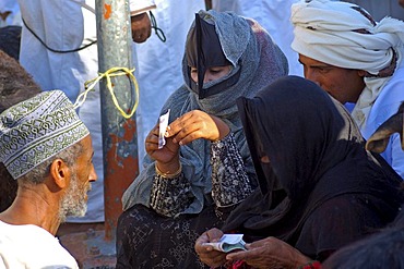 Omani women counting money after trading at the goat market, Nizwa, Sultanate of Oman, Middle East