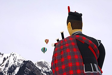 Hot-air balloons, rear view of the special form of a flying scotsman, Cameron ss Balloon Piper-105, two round balloons over snow-covered mountains, Balloon festival Chateau d'Oex, Switzerland, Europe