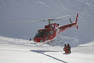 Rescue helicopter taking-off after the rescue of an injured skier on Leukerbad ski piste, Valais, Switzerland, Europe