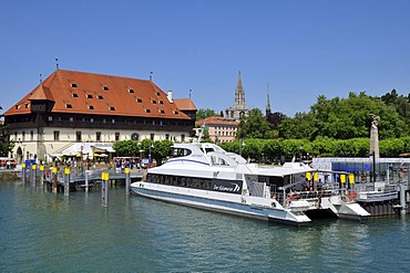 Konzilgebaeude building and a modern catamaran motor yacht in front of the Konstanzer Muenster, or Cathedral of Constance, Constance Harbour, Lake Constance, Baden-Wuerttemberg, Germany, Europe