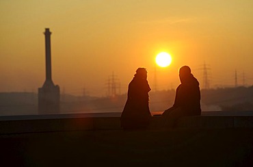 Two people in the forefront of EnBW Energiepark at sunset, Marbach on the Neckar, Baden-Wuerttemberg, Germany, Europe