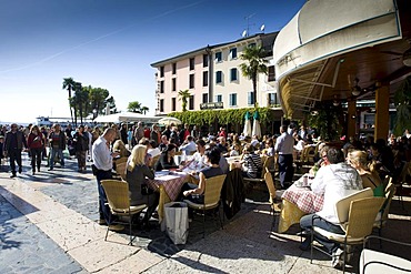 Tourists sitting in a restaurant on the promenade of Sirmione, Lake Garda, Lago di Garda, Lombardy, Italy, Europe