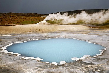 Blahver, blue spring, the most beautiful blue water pool in Hveravellir in the Highlands, in front of Oeskjuholt, a steaming calc-sinter mound which looks like a mini volcano, Hveravellir, Iceland, Europe