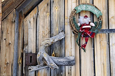 Christmas wreath decoration on wilderness lodge door in Saariselkae skiing region, Ivalo, Lapland, Finland, Europe