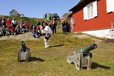 Inuit wearing a traditional costume, folklore in front of a museum in Tasiilaq, Ammassalik, East Greenland, Greenland