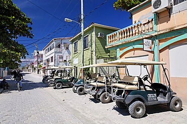 Golf carts parked on the main street, the most popular form of transport in San Pedro, Ambergris Cay Island, Belize, Central America, Caribbean