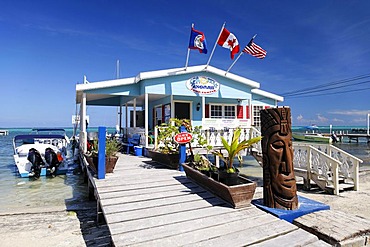 Carved wooden face in front of a restaurant on a pier in the ocean of San Pedro, Ambergris Cay Island, Belize, Central America, Caribbean