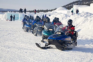 Group of snow scooter drivers starting in front of the Icehotel in Jukkasjaervi, Lappland, North Sweden, Sweden