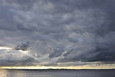 Dramatic evening sky with golden horizon and menacing storm clouds, Ruegen Island, Mecklenburg-Western Pomerania, Germany, Europe