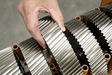 An employee of the Heidelberger Druckmaschinen AG taking a gear in his hand, manufacture of offset-printing machines of the Heidelberger Druckmaschinen AG in Wiesloch near Heidelberg, Baden-Wuerttemberg, Germany, Europe