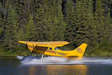 Starting float plane, bush plane, Cessna 206, Caribou Lakes, Liard River, British Columbia, Yukon Territory, Canada, North America