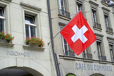 Swiss flag hanging from a building facade, Bern, Switzerland, Europe