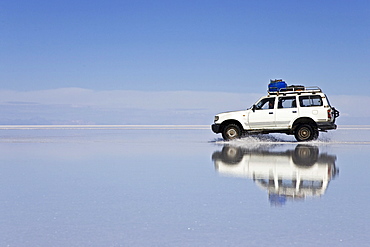 Driving car on the salt lake Salar de Uyuni, Altiplano, Bolivia, South America