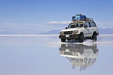 Driving car on the salt lake Salar de Uyuni, Altiplano, Bolivia, South America