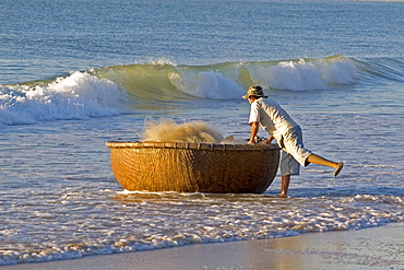 Vietnamese fisherman bringing in his basket boat, beach at Mui Ne, Vietnam, Southeast Asia, Asia