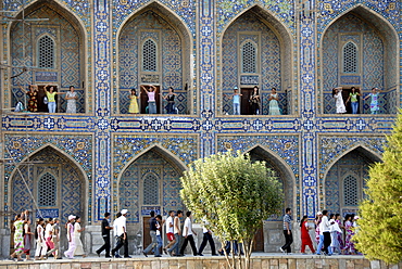 Young women dancing in arches of Madrasah Tilla-kari Registan Samarkand Uzbekistan