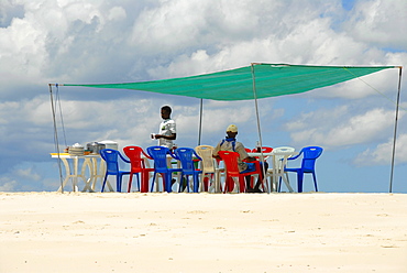 Table and chairs in the shade for lunch on a white sand bank near Kizimkazi Zanzibar Tanzania